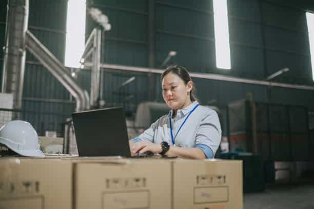 Female worker using laptop to manage export documentation