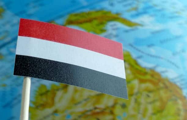 Yemen flag with blurred world map background symbolizing global trade