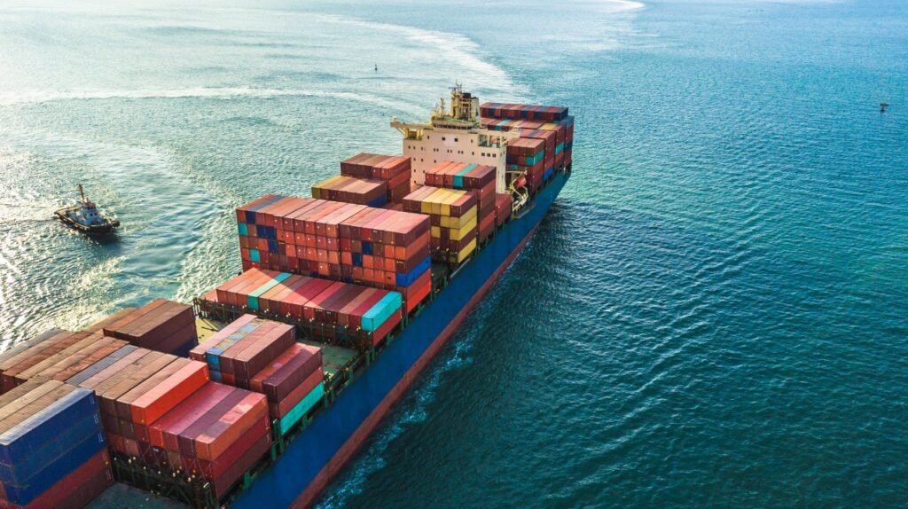 Container ship sailing across open sea with stacked colorful containers on route to Southeast Asia