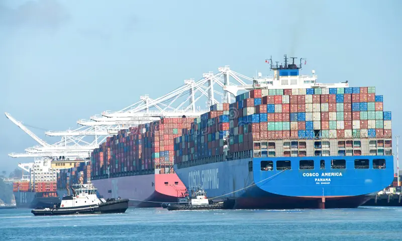 COSCO container ship docked at port with heavy cranes loading cargo for international maritime transport