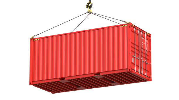 A standard red 20 feet container suspended by a crane, depicting the loading process at a busy port terminal.